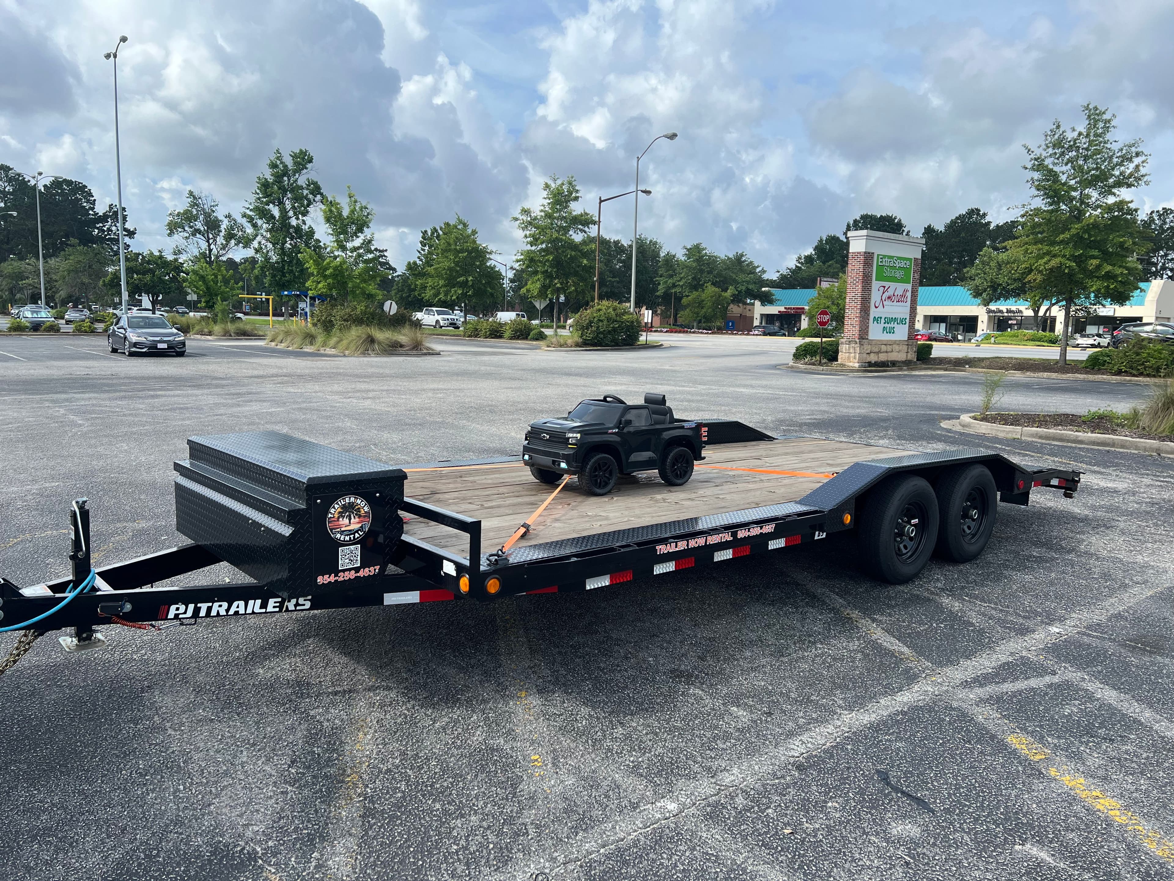 Child's electric Chevrolet truck on car hauler in parking lot
