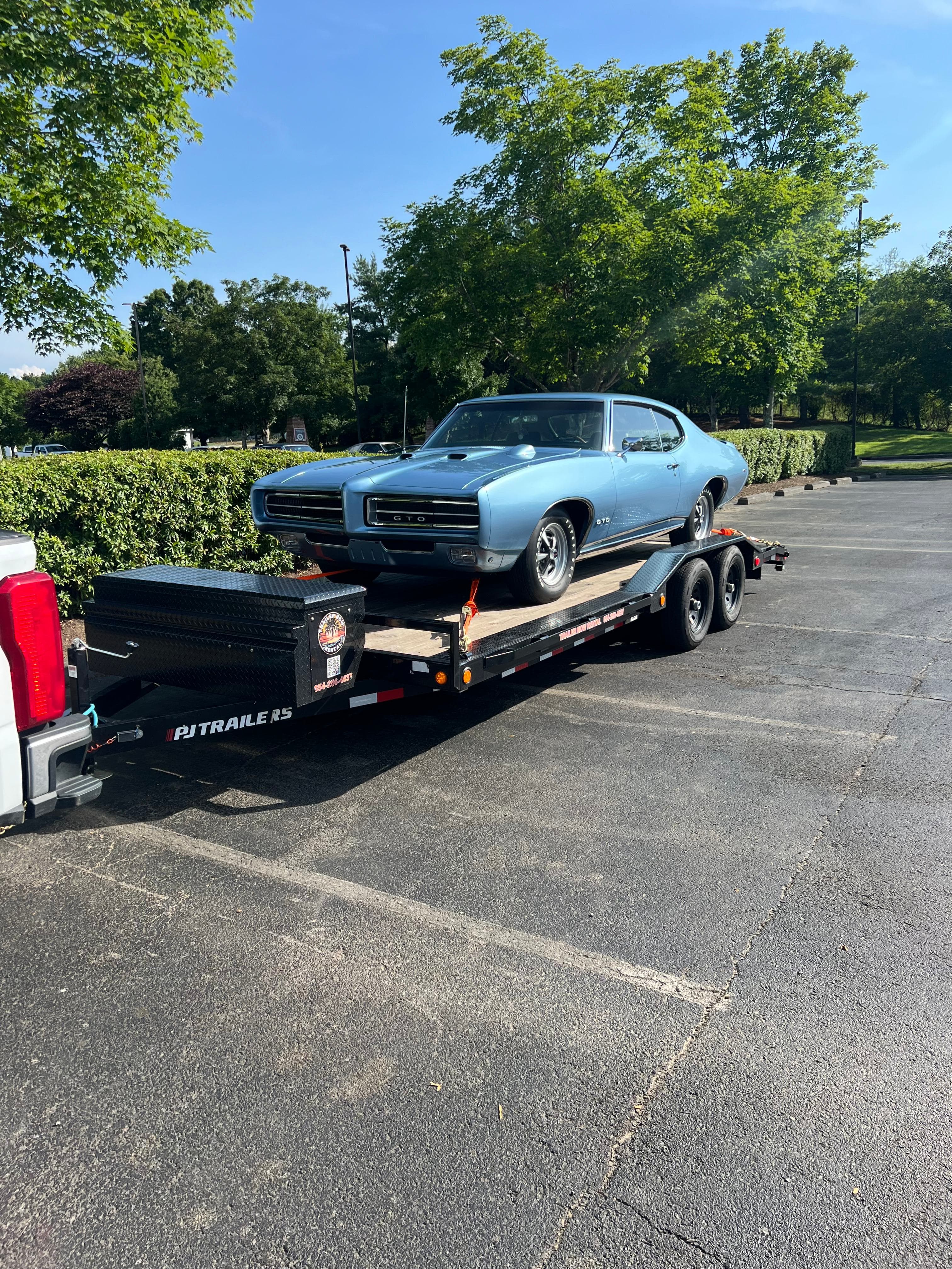 Light blue vintage Pontiac GTO on car hauler