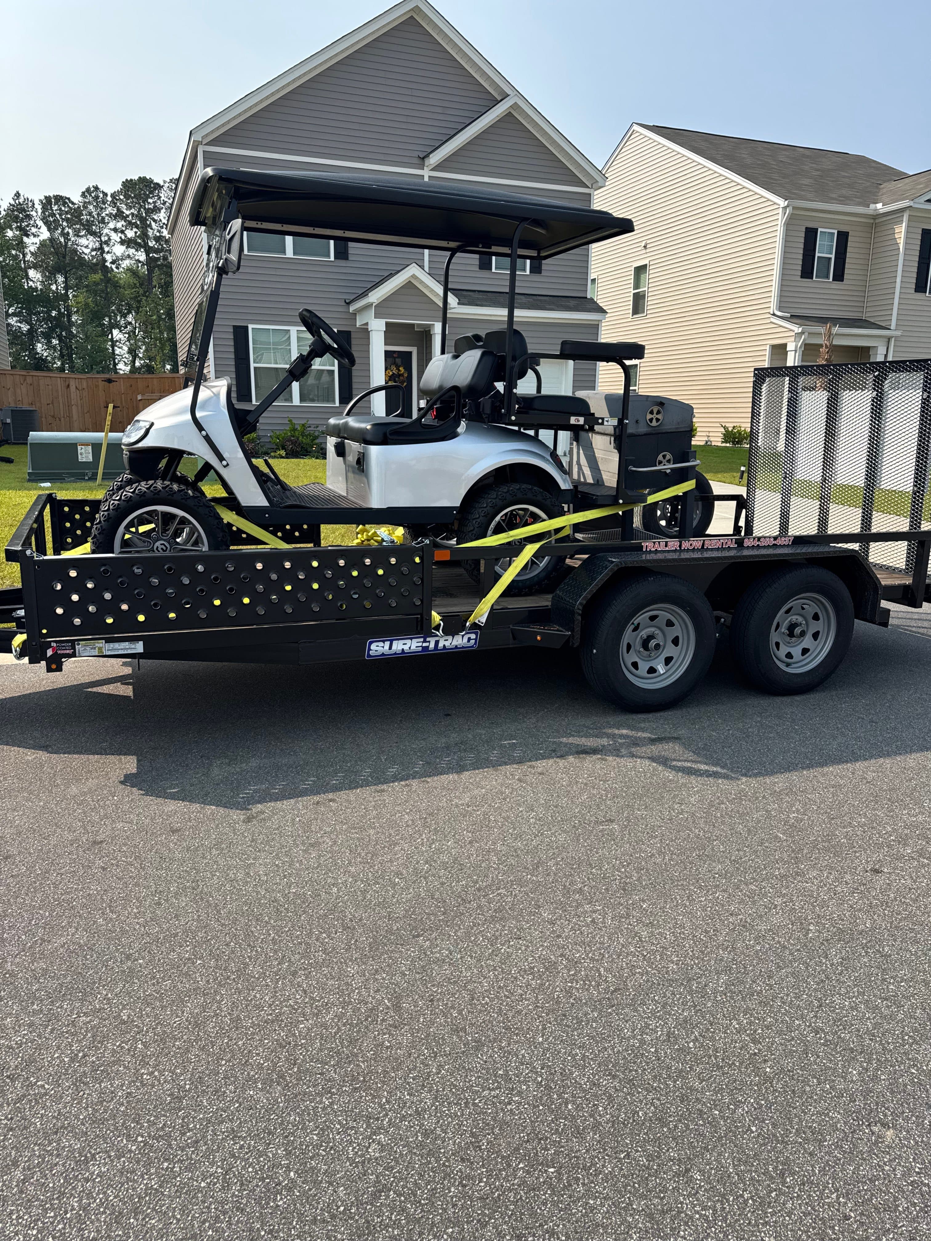 White golf cart on utility trailer